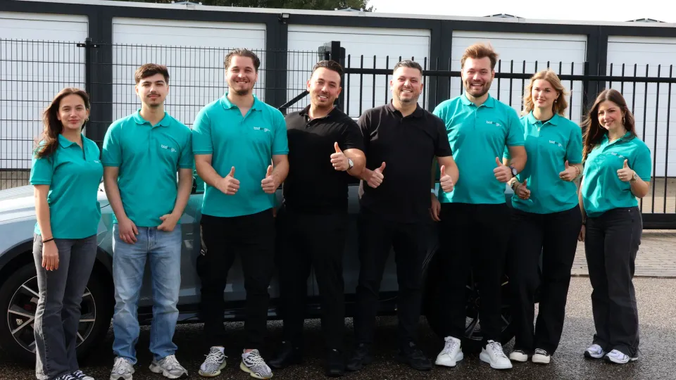 Het team van Bodengo bij een auto op het bedrijfsterrein